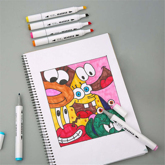 Colorful cartoon character drawing surrounded by alcohol markers on a spiral notebook.